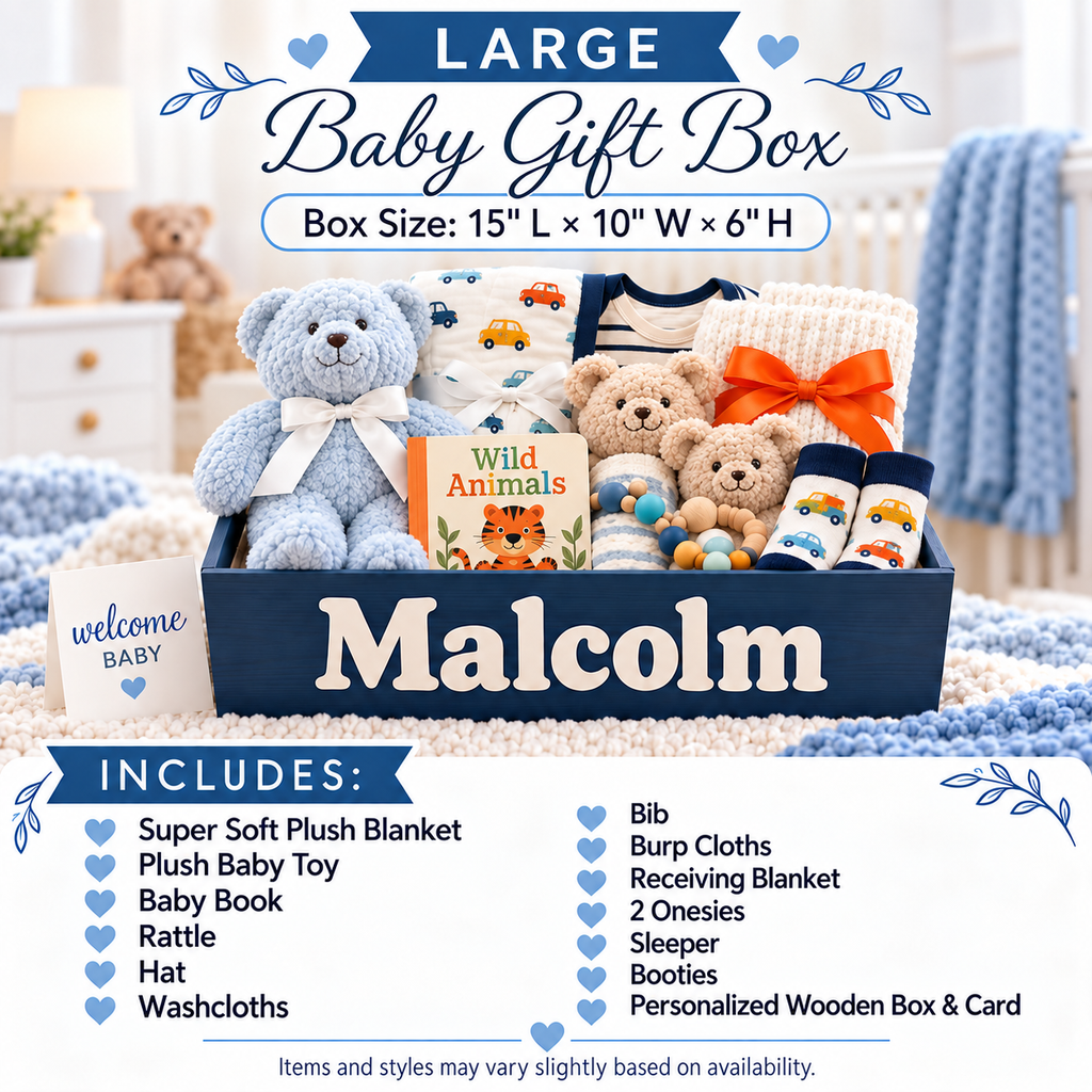 Large personalized baby gift box set shown in a nursery-like setting, containing a plush teddy bear, baby book, socks, blankets, and a bib. The navy box is personalized with the name 'Malcolm' in large white letters.